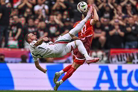 Attila Fiola and Ruben Vargas challenge for the ball